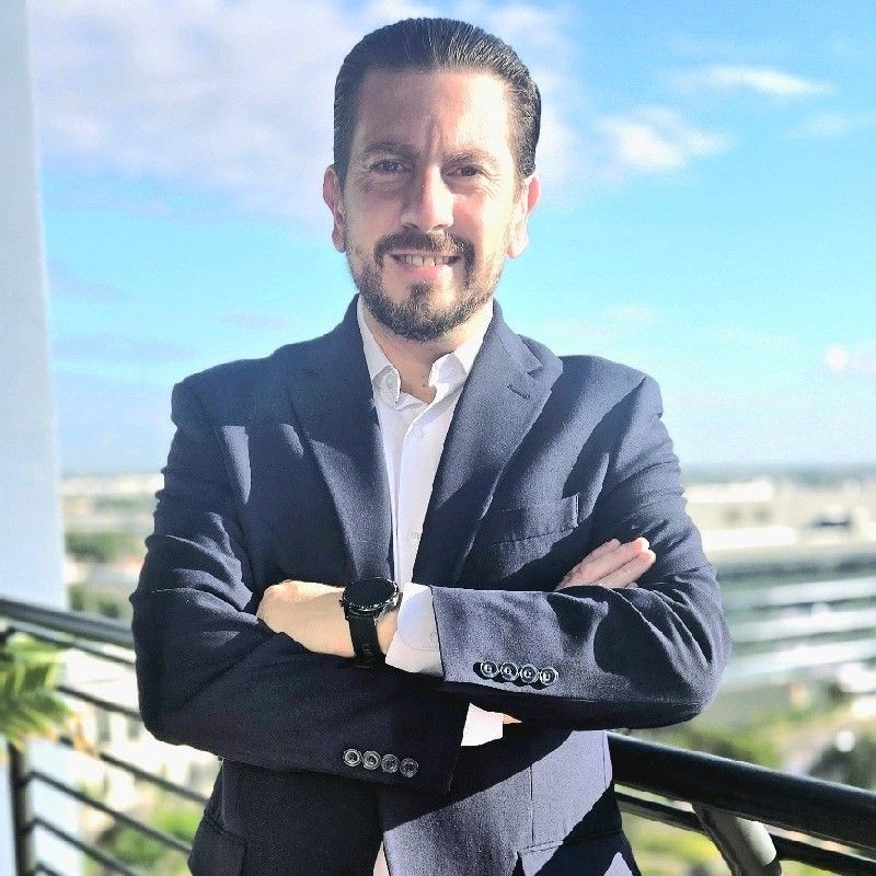 Paulo Lara, Founder and Strategic Consultant at Pavali Consulting, expert in AI consulting, NLP, and business strategy, wearing a navy blazer outdoors